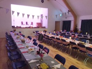 Tables set for a meal in Ashurst village Hall