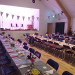 Tables set for a meal in Ashurst village Hall