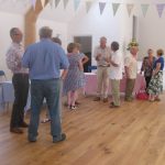 People at an event in Ashurst Village hall, which is decorated with bunting